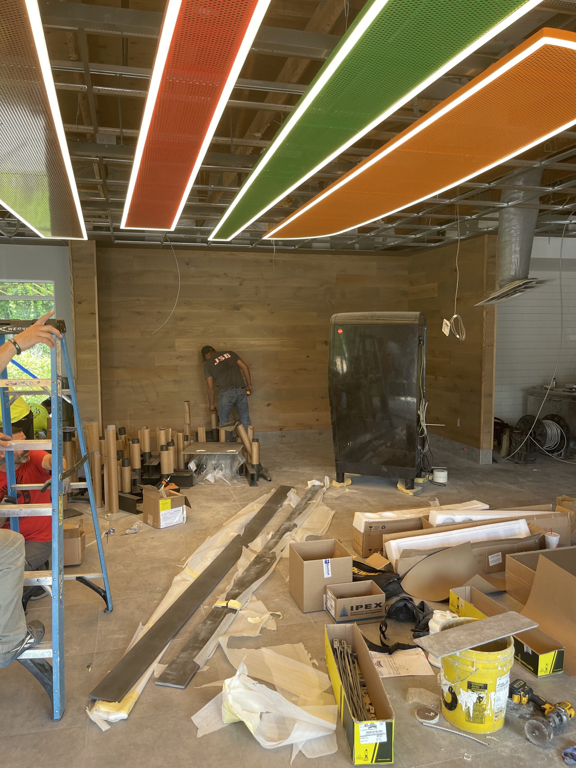 Office construction in progress with steel stud framing, open floor plan layout, and exposed ceiling structure